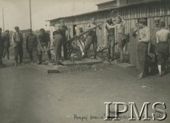 Lipiec - grudzień 1917, Szczypiorno k. Kalisza.
Żołnierze I i II Brygady Legionów, internowani w obozie jenieckim po odmowie przysięgi na wierność Niemcom. Legioniści obsługujący pompę. Podpis: 