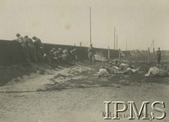 Lipiec - grudzień 1917, Szczypiorno k. Kalisza.
Żołnierze I i II Brygady Legionów, internowani w obozie jenieckim po odmowie przysięgi na wierność Niemcom. Grupa legionistów podczas czytania. Podpis: 