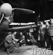 1940-1941, Wielka Brytania.
Dywizjon 303, mechannicy obok samolotu stojącego w hangarze. Od lewej: plut. Lendzowski (?), kpr. Pawlikowski, szer. Kopczyński, szer. Brzeziński, kpr. Prokop, sierż. Krynicki, plut. Chmielecki, kpr. Pacek, st. sierż. Sobek, plut. Letniewski, st. sierz. Henryk Starzyński. Na skrzydle siedzi kpr. Kobylański.
Fot. NN, Instytut Polski i Muzeum im. gen. Sikorskiego w Londynie