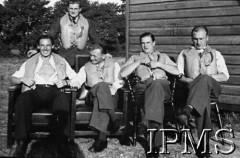 Przed 27.09.1940, Northolt, Anglia, Wielka Brytania.
Piloci dywizjonu 303 w gotowości bojowej, siedzą od lewej: por. Kazimierz Daszewski (zginął 4 kwietnia 1942), sierż. Mirosław Wojciechowski (stoi), por. Ludwik Paszkiewicz (zginął 27 września 1940), por. Witold Łokuciewski, por. Wacław Łapkowski (zginął 2 lipca 1941).
Fot. NN, Instytut Polski i Muzeum im. gen. Sikorskiego w Londynie