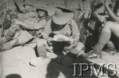 1940-1942, brak miejsca.
Polscy żołnierze w mundurach tropikalnych w obozie wojskowym. Na pierwszym planie żołnierz z mapą.
Fot. NN, Instytut Polski im. Gen. Sikorskiego w Londynie [koperta - Włosi].