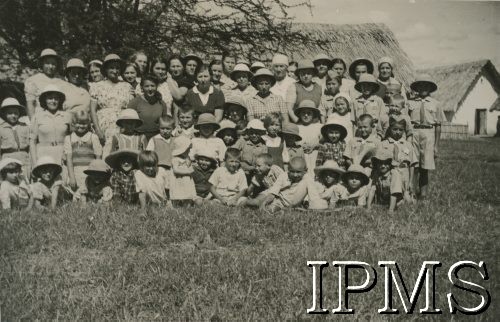 1943, Kondoa, Tanganika.
Osiedle dla polskich uchodźców, fotografia grupowa harcerzy i kobiet.
[Polscy uchodźcy w 1942 trafili do Iranu wraz z nowoutworzonym Wojskiem Polskim pod dowództwem generała Władysława Andersa (w dwóch rzutach ewakuacyjnych z ZSRR w marcu i sierpniu). W sumie oprócz wojska dotarło tam 38 tysięcy Polaków, z czego ponad połowę stanowiły dzieci i młodzież. Ok. 20 tys. znalazło się następnie w Afryce, polskie osiedla znajdowały się przede wszystkim w: Ugandzie, Kenii, Tanganice, Rodezji Północnej i Rodezji Południowej, Związku Południowej Afryki. Kondoa było najmniejszym polskim osiedlem w Afryce Wschodniej].
Fot. NN, Instytut Polski i Muzeum im. gen. Sikorskiego w Londynie [album 288 - gen. Andersowi uchodźstwo w Afryce Wsch. 19.07.1943, w albumie dedykacja: panu generałowi Władysławowi Andersowi w imieniu uchodźstwa w Afryce inż. K. Kazimierczak, delegat MPiOS Nairobi].
