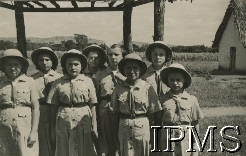 1943, Kondoa, Tanganika.
Osiedle dla polskich uchodźców, grupa harcerek.
[Polscy uchodźcy w 1942 trafili do Iranu wraz z nowoutworzonym Wojskiem Polskim pod dowództwem generała Władysława Andersa (w dwóch rzutach ewakuacyjnych z ZSRR w marcu i sierpniu). W sumie oprócz wojska dotarło tam 38 tysięcy Polaków, z czego ponad połowę stanowiły dzieci i młodzież. Ok. 20 tys. znalazło się następnie w Afryce, polskie osiedla znajdowały się przede wszystkim w: Ugandzie, Kenii, Tanganice, Rodezji Północnej i Rodezji Południowej, Związku Południowej Afryki. Kondoa było najmniejszym polskim osiedlem w Afryce Wschodniej].
Fot. NN, Instytut Polski i Muzeum im. gen. Sikorskiego w Londynie [album 288 - gen. Andersowi uchodźstwo w Afryce Wsch. 19.07.1943, w albumie dedykacja: panu generałowi Władysławowi Andersowi w imieniu uchodźstwa w Afryce inż. K. Kazimierczak, delegat MPiOS Nairobi].
