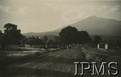 1943, Tengeru, Tanganika.
Widok polskiego osiedla z górującym nad nim wulkanem Meru.
[Polscy uchodźcy w 1942 trafili do Iranu wraz z nowoutworzonym Wojskiem Polskim pod dowództwem generała Władysława Andersa (w dwóch rzutach ewakuacyjnych z ZSRR w marcu i sierpniu). W sumie oprócz wojska dotarło tam 38 tysięcy Polaków, z czego ponad połowę stanowiły dzieci i młodzież. Ok. 20 tys. znalazło się następnie w Afryce, polskie osiedla znajdowały się przede wszystkim w: Ugandzie, Kenii, Tanganice, Rodezji Północnej i Rodezji Południowej, Związku Południowej Afryki. Tengeru było największym polskim osiedlem uchodźczym w Afryce].
Fot. NN, Instytut Polski i Muzeum im. gen. Sikorskiego w Londynie [album 288 - gen. Andersowi uchodźstwo w Afryce Wsch. 19.07.1943, w albumie dedykacja: panu generałowi Władysławowi Andersowi w imieniu uchodźstwa w Afryce inż. K. Kazimierczak, delegat MPiOS Nairobi].
