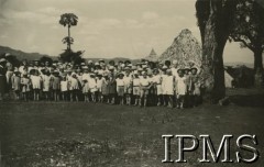 1943, Tengeru, Tanganika.
Osiedle dla polskich uchodźców, grupa uczniów.
[Polscy uchodźcy w 1942 trafili do Iranu wraz z nowoutworzonym Wojskiem Polskim pod dowództwem generała Władysława Andersa (w dwóch rzutach ewakuacyjnych z ZSRR w marcu i sierpniu). W sumie oprócz wojska dotarło tam 38 tysięcy Polaków, z czego ponad połowę stanowiły dzieci i młodzież. Ok. 20 tys. znalazło się następnie w Afryce, polskie osiedla znajdowały się przede wszystkim w: Ugandzie, Kenii, Tanganice, Rodezji Północnej i Rodezji Południowej, Związku Południowej Afryki. Tengeru było największym polskim osiedlem uchodźczym w Afryce].
Fot. NN, Instytut Polski i Muzeum im. gen. Sikorskiego w Londynie [album 288 - gen. Andersowi uchodźstwo w Afryce Wsch. 19.07.1943, w albumie dedykacja: panu generałowi Władysławowi Andersowi w imieniu uchodźstwa w Afryce inż. K. Kazimierczak, delegat MPiOS Nairobi].
