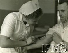 Maj 1944, Cassino, Włochy.
Szpital polowy, pielęgniarka pobiera krew żołnierzowi.
Fot. NN, Instytut Polski i Muzeum im. gen. Sikorskiego w Londynie [album 369 - 3 Dywizja Strzelców Karpackich].