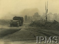 8.08.1944, Caen, Francja.
Samochód 1 Dywizji Pancernej przejeżdża przez ruiny miasta.
Fot. J. Z. Żegota-Januszajtis, Instytut Polski i Muzeum im. gen. Sikorskiego w Londynie [paczka 1 Dywizja Pancerna].