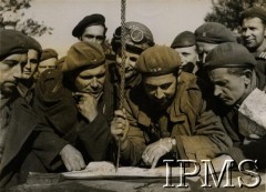 Październik-listopad 1944, Breda (okolice), Holandia.
Polskie i kanadyjskie wojska w trakcie walk na linii Tilburg-Breda. Fotografia zrobiona po zdobyciu przez 1 Dywizję Pancerną Gilze w dniu 27 październik 1944 roku. Żołnierze studiują mapę podczas natarcia z Gilze.
Fot. NN, Instytut Polski i Muzeum im. gen. Sikorskiego w Londynie [szuflada 25 - saperzy, komandosi, spadochroniarze]