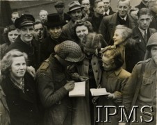 Po 29.10.1944, prawdopodobnie Breda, Holandia.
Żołnierze 1 Dywizji Pancernej rozdają autografy miejscowej ludności.
Fot. NN, Instytut Polski i Muzeum im. gen. Sikorskiego w Londynie [szuflada 44 - Belgia, Holandia]