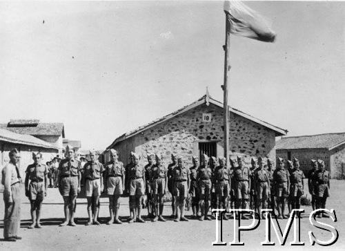 1942-1946, Balachadi k. Jamnagar, Indie.
Osiedle dla dzieci polskich ewakuowanych ze Związku Radzieckiego, harcerze na placu apelowym pod polską flagą.
[Polscy uchodźcy w 1942 roku trafili do Iranu wraz z nowoutworzonym Wojskiem Polskim pod dowództwem generała Władysława Andersa (w dwóch rzutach ewakuacyjnych z ZSRR w marcu i sierpniu). W sumie oprócz wojska dotarło tam 38 tys. Polaków, z czego ponad połowę stanowiły dzieci i młodzież. Około 10 tys. z nich trafiła potem do Indii. Osiedle w Balachadi było pierwszym w Indiach stałym polskim osiedlem uchodźczym].
Fot. NN, Instytut Polski i Muzeum im. gen. Sikorskiego w Londynie [szuflada 45 - Polacy na emigracji].