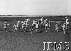 1942-1946, Balachadi k. Jamnagar, Indie.Osiedle dla dzieci polskich ewakuowanych ze Związku Radzieckiego, na zdjęciu grupa dzieci w towarzystwie opiekunów.[Polscy uchodźcy w 1942 roku trafili do Iranu wraz z nowoutworzonym Wojskiem Polskim pod dowództwem generała Władysława Andersa (w dwóch rzutach ewakuacyjnych z ZSRR w marcu i sierpniu). W sumie oprócz wojska dotarło tam 38 tys. Polaków, z czego ponad połowę stanowiły dzieci i młodzież. Około 10 tys. z nich trafiła potem do Indii. Osiedle w Balachadi było pierwszym w Indiach stałym polskim osiedlem uchodźczym].Fot. NN, Instytut Polski i Muzeum im. gen. Sikorskiego w Londynie [szuflada 45 - Polacy na emigracji].