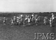 1942-1946, Balachadi k. Jamnagar, Indie.Osiedle dla dzieci polskich ewakuowanych ze Związku Radzieckiego, na zdjęciu grupa dzieci w towarzystwie opiekunów.[Polscy uchodźcy w 1942 roku trafili do Iranu wraz z nowoutworzonym Wojskiem Polskim pod dowództwem generała Władysława Andersa (w dwóch rzutach ewakuacyjnych z ZSRR w marcu i sierpniu). W sumie oprócz wojska dotarło tam 38 tys. Polaków, z czego ponad połowę stanowiły dzieci i młodzież. Około 10 tys. z nich trafiła potem do Indii. Osiedle w Balachadi było pierwszym w Indiach stałym polskim osiedlem uchodźczym].Fot. NN, Instytut Polski i Muzeum im. gen. Sikorskiego w Londynie [szuflada 45 - Polacy na emigracji].