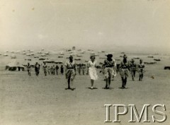 1943, Środkowy Wschód.
Widok na polski obóz, na pierwszym planie grupa oficerów Armii Andersa i kobieta w białej sukience.
Fot. NN, Instytut Polski i Muzeum im. gen. Sikorskiego w Londynie

