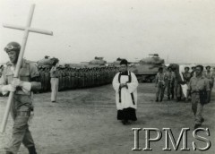 Lata 40., Środkowy Wschód.
Wojskowy pogrzeb, ksiądz idący za żołnierzem niosącym krzyż, z tyłu żołnierze niosący trumnę przykrytą polską flagą, w tle grupa czołgistów.
Fot. NN, Instytut Polski i Muzeum im. gen. Sikorskiego w Londynie