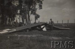 1936-1937, Polska.
Dwaj żołnierze stoją obok wraku rozbitego samolotu.
Opis do albumu: Album pchor. kaprala lotnictwa 2 pułku lotniczego Kraków - Tadeusza Strumińskiego (ur. 1914), który zginął śmiercią lotnika w Biskupicach koło Pilicy 11.09.1937 w czasie lotu treningowego samolotem RWD 8. 
Fot. NN, Instytut Polski im. Gen. Sikorskiego w Londynie [Album Strumińskich]