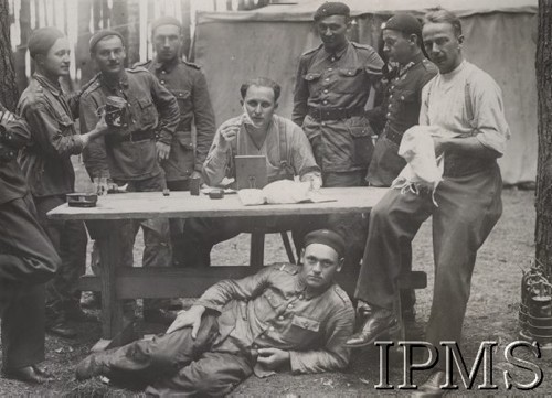 1936-1937, Polska.
Słuchacze Szkoły Podchorążych Lotnictwa przed namiotem, jeden z lotników goli się, siedząc za stołem.
Opis do albumu: Album pchor. kaprala lotnictwa 2 pułku lotniczego Kraków - Tadeusza Strumińskiego (ur. 1914), który zginął śmiercią lotnika w Biskupicach koło Pilicy 11.09.1937 w czasie lotu treningowego samolotem RWD 8. 
Fot. NN, Instytut Polski im. Gen. Sikorskiego w Londynie [Album Strumińskich]
