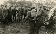 Lata 40., Wielka Brytania.
Polscy i brytyjscy oficerowie przygladają się polskim żołnierzom, którzy ciągną działo.
Fot. NN, Instytut Polski i Muzeum im. gen. Sikorskiego w Londynie