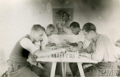 1940-1941, Montestruc-sur-Gers, Francja.
Świetlica w obozie dla internowanych polskich żołnierzy. Gra w szachy. W tle wisi portret Marszałka Józefa Piłsudskiego, opierającego dłoń na głowni miecza.
Fot. NN, Instytut Polski i Muzeum im. gen. Sikorskiego w Londynie [kolekcja F. Bahyrycza]