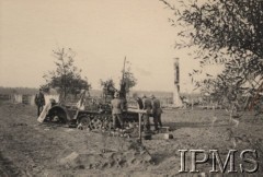Wrzesień 1939, Polska.
Kampania wrześniowa, wkroczenie oddziałów niemieckich do Polski. Niemieccy żołnierze ogladają zniszczony ciągnik artyleryjski. Na pierwszym planie mogiła żołnierza. Fotografia wykonana przez nieznanego żołnierza Wehrmachtu.
Fot. NN, Instytut Polski im. Gen. Sikorskiego w Londynie [teczka nr 140a]