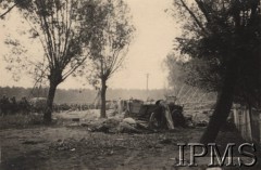 Wrzesień 1939, Polska.
Kampania wrześniowa, wkroczenie oddziałów niemieckich do Polski. Rozbity wóz uciekinierów i martwe konie leżące na drodze, w tle maszerujący oddział niemieckiej piechoty. Fotografia wykonana przez nieznanego żołnierza Wehrmachtu.
Fot. NN, Instytut Polski im. Gen. Sikorskiego w Londynie [teczka nr 140a]