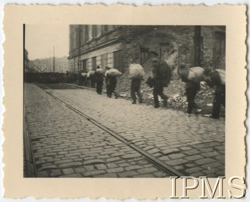 22.08.1944, Warszawa, Generalne Gubernatorstwo.
Powstanie Warszawskie, grupa powstańców niosących worki ulicą, w tle barykada.
Fot. NN, Instytut Polski i Muzeum im. gen. Sikorskiego w Londynie, teczka 81