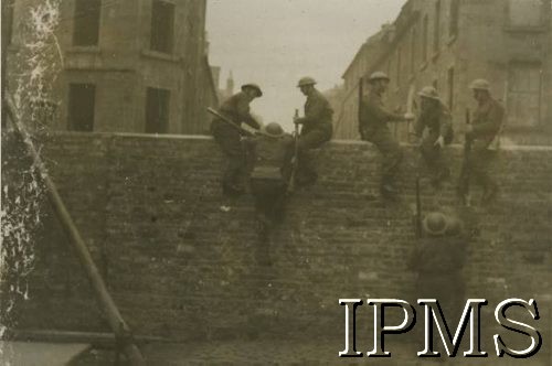 1940-1945, brak miejsca.
Polskie Siły Zbrojne na Zachodzie, żołnierze podczas przechodzenia przez mur.
Fot. NN, Instytut Polski i Muzeum im. gen. Sikorskiego w Londynie [album 53 - PSZ na Zachodzie, 1 Dywizja Pancerna, 10 Pułk Dragonów].