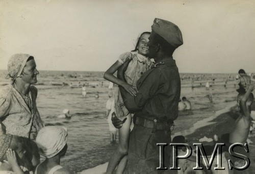 Sierpień 1942, Pahlewi, Iran (Persja).
Polacy ewakuowani ze Związku Radzieckiego razem z Armią Andersa. Dzieci kąpią się w Morzu Kaspijskim, na pierwszym planie dziewczynka w ramionach żołnierza.
Fot. NN, Instytut Polski i Muzeum im. gen. Sikorskiego w Londynie