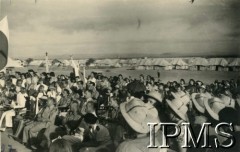 3.05.1944, Karachi, Indie.
Obóz przejściowy dla polskich uchodźców. Obchody rocznicy uchwalenia Konstytucji 3 Maja. Mieszkańcy obozu i goście uczestniczą w polowej mszy świętej.
Fot. NN, Kronika osiedla polskiego Valivade-Kolhapur, Indie, tom III, Instytut Polski i Muzeum im. gen. Sikorskiego w Londynie