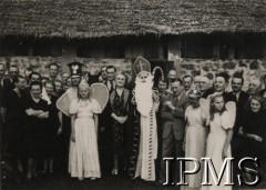 1944, Tengeru, Tanganika.
Osiedle dla polskich uchodźców. Grupa mieszkańców osiedla ze św. Mikołajem. Z przodu stoją m.in. brytyjski komendant osiedla pułkownik John Minnery i jego żona Mary.
Fot. NN, kolekcja: Osiedla polskie w Afryce, Instytut Polski i Muzeum im. gen. Sikorskiego w Londynie
