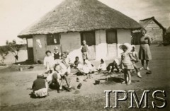 1944, Marandellas, Rodezja Południowa. 
Osiedle dla polskich uchodźców. Przedszkolaki podczas zabawy w piasku, przed budynkiem przedszkola. Z prawej stoi przedszkolanka. 
Fot. NN, kolekcja: Osiedla polskie w Afryce, Instytut Polski i Muzeum im. gen. Sikorskiego w Londynie