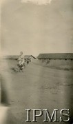 1945, Rongai, Kenia. 
Osiedle dla polskich uchodźców. Kobieta jadąca na rowerze. W tle - zabudowania.
Fot. Bus, kolekcja: Osiedla polskie w Afryce, Instytut Polski i Muzeum im. gen. Sikorskiego w Londynie