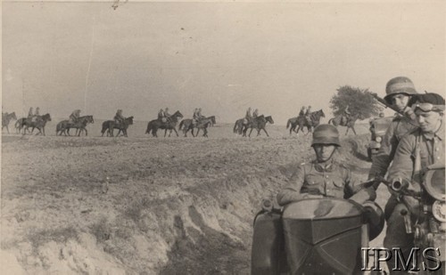 1938, Polska.
Na pierwszym planie trzej żołnierze w motocyklu, w tle oddział kawalerii.
Fot. NN, Instytut Polski i Muzeum im. gen. Sikorskiego w Londynie [album fotograficzny Dywizjonu Rozpoznawczego 10 BKZ - część II]