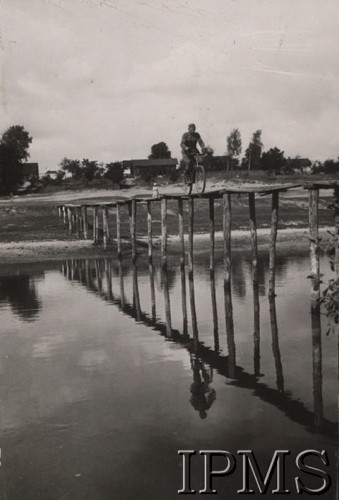 1920-1939, Polska.
Żołnierz jadący na rowerze po kładce na palach przerzuconej przez rzekę.
Fot. NN, Instytut Polski im. Gen. Sikorskiego w Londynie [Album Korpusu Ochrony Pogranicza - przekazany przez kpt. Jana Sas-Tatomira]