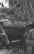 Maj 1944, Cassino, Włochy.
Bitwa pod Monte Cassino, czołgiści spożywający posiłek obok swojego czołgu, pod siatką maskującą.
Fot. T. Szumański, Instytut Polski im. Gen. Sikorskiego w Londynie [album negatywowy nr 105]

