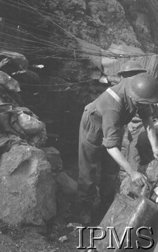 Maj 1944, Cassino, Włochy.
Bitwa pod Monte Cassino, dwaj żołnierze 2 Korpusu przed schronem zamaskowanym gałęziami. 
Fot. T. Szumański, Instytut Polski im. Gen. Sikorskiego w Londynie [album negatywowy nr 105]

