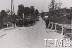 Czerwiec 1941, rzeka Ropa.
Przemarsz 1 Dywizji Strzelców Górskich przez most na Ropie. Żołnierze mijają tabliczkę z nazwą miejscowości: „ROPA brick” oraz umieszczone na słupach znaki swastyki. W oddali - położone na wzgórzach domy mieszkalne, przydrożne drzewa.
Fot. NN, Instytut Polski i Muzeum im. gen. Sikorskiego w Londynie 
