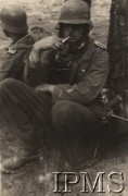 1939-1943, brak miejsca.
Odpoczynek szeregowego i podoficera 1 Dywizji Strzelców Górskich. U pierwszego żołnierza widoczny jest: pistolet maszynowy MP-40, pojemnik na maskę przeciwgazową, lornetka. Żołnierze mają na sobie okute buty - element rozpoznawczy oddziałów górskich. 
Fot. NN, Instytut Polski i Muzeum im. gen. Sikorskiego w Londynie