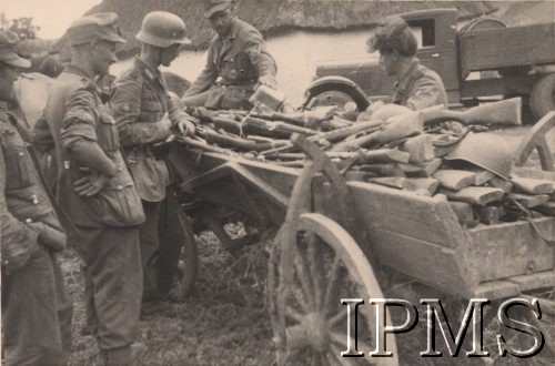 Po 22.06.1941, brak miejsca.
Żołnierze z jednostki I Dywizji Strzelców Górskich oglądają znajdujący się na wozie, zdobyczny sprzęt radziecki – karabiny typu Mosin, SWT-40 oraz hełmy. Na drugim planie widoczny jest samochód  ZIS-5 oraz wiejska chata.
Fot. NN, Instytut Polski i Muzeum im. gen. Sikorskiego w Londynie
