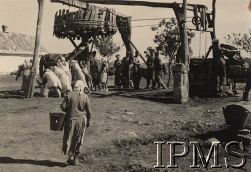 Po 22.06.1941, brak miejsca.
I Dywizja Strzelców Górskich - żołnierze oraz ludność cywilna stoją przy kołowrocie studni. Na pierwszym planie - kobieta z wiadrem, w oddali widoczny jest fragment zabudowy wiejskiej.   
Fot. NN, Instytut Polski i Muzeum im. gen. Sikorskiego w Londynie