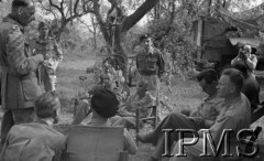 Maj 1944, Cassino, Włochy. 
Kwatera Dywizji 2 Korpusu, gen. Władysława Anders siedzi (tyłem) z grupką korespondentów prasowych, z lewej stoi ppor. Eugeniusz Lubomirski z kartką w ręku.
Fot. Felicjan Maliniak, Instytut Polski im. Gen. Sikorskiego w Londynie [album negatywowy L-I Monte Cassino] - płachta 45