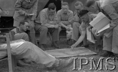 Maj 1944, Cassino, Włochy.
Kwatera Dywizji 2 Korpusu, gen. Władysław Anders nachylony nad mapą rozpostartą na ziemi, obok oficerowie i korespondenci wojenni.
Fot. Felicjan Maliniak, Instytut Polski im. Gen. Sikorskiego w Londynie [album negatywowy L-I Monte Cassino] - płachta 45
