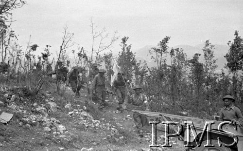 Maj 1944, Cassino, Włochy.
Sanitariusze ze sztandarem Czerwonego Krzyża znoszą zwłoki z pola bitwy.
Fot. Felicjan Maliniak, Instytut Polski im. Gen. Sikorskiego w Londynie [album negatywowy L-I Monte Cassino] - płachta 49