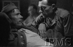 Maj 1944, Cassino, Włochy.
Ranny i nachylony nad nim sanitariusz.
Fot. por. Ostrowski, Instytut Polski im. Gen. Sikorskiego w Londynie [album negatywowy L-II Monte Cassino] - płachta 2
