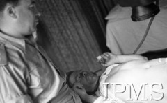 Maj 1944, Cassino, Włochy.
Szpital polowy, lekarz i ranny.
Fot. por. Ostrowski, Instytut Polski im. Gen. Sikorskiego w Londynie [album negatywowy L-II Monte Cassino] - płachta 2
