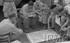 Maj 1944, Cassino, Włochy.
Kwatera Główna Dowódcy 2 Korpusu. Gen. Władysław Anders nachylony nad mapą leżącą na ziemi objaśnia dziennikarzom sytuację wojska polskiego w czasie bitwy, obok generała z lewej siedzi major Józef Czapski. 
Fot. por. Ostrowski, Instytut Polski im. Gen. Sikorskiego w Londynie [album negatywowy L-II Monte Cassino] - płachta 3
