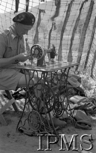 Maj 1944, Cassino, Włochy.
Krawiec przy maszynie do szycia pod siatką maskującą.
Fot. por. Ostrowski, Instytut Polski im. Gen. Sikorskiego w Londynie [album negatywowy L-II Monte Cassino] - płachta 7