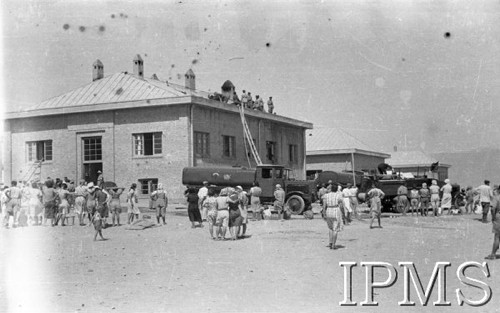 1942, Teheran, Iran (Persja).
Obóz nr 2 dla polskich uchodźców - wozy strażackie koło budynku, który się pali. Do budynku przystawione drabiny, na dachu żołnierze ratujący dom.
Fot. NN, Instytut Polski im. Gen. Sikorskiego w Londynie [album negatywowy B-I IRAN] - płachta 34