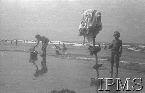 Sierpień 1942, Pahlewi, Iran (Persja).
Nad brzegiem morza w gorący dzień przyjemnie małemu junakowi stać w wodzie.
Fot. NN, Instytut Polski im. Gen. Sikorskiego w Londynie [album negatywowy B-I IRAN] - płachta 35