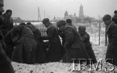 Grudzień 1941, Buzułuk, obł. Czkałowsk, ZSRR.
Koledzy spuszczają trumnę do grobu - Szwadron Przyboczny (12 Pułk Ułanów) Dowództwa Armii na Wschodzie, pogrzeb jednego z kolegów oficera Tytusa.
Fot. Czesław Zembal, Instytut Polski im. Gen. Sikorskiego w Londynie  - płachta 5