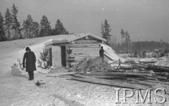 Grudzień 1941, Kołtubanka, obł. Czkałowsk, ZSRR.
Barak dla żołnierzy wkopany głęboko w ziemię celem zabezpieczenia od mrozu - na tle baraku postać żołnierza.
Fot. Czesław Zembal, Instytut Polski im. Gen. Sikorskiego w Londynie [album negatywowy A-I ROSJA] - płachta 10